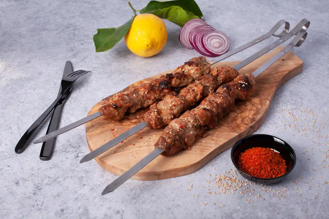 Schweine Schaschlik Yaku3a auf Spießen auf Holzbrett serviert mit rotem Pfeffer Zwiebeln