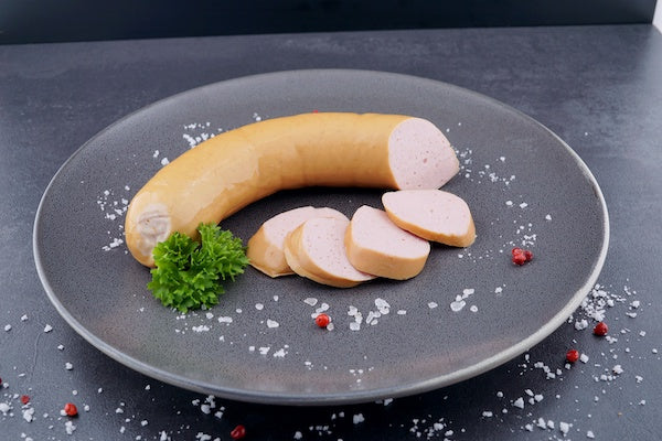 Fleischwurst geschnitten auf Teller mit Petersilie serviert