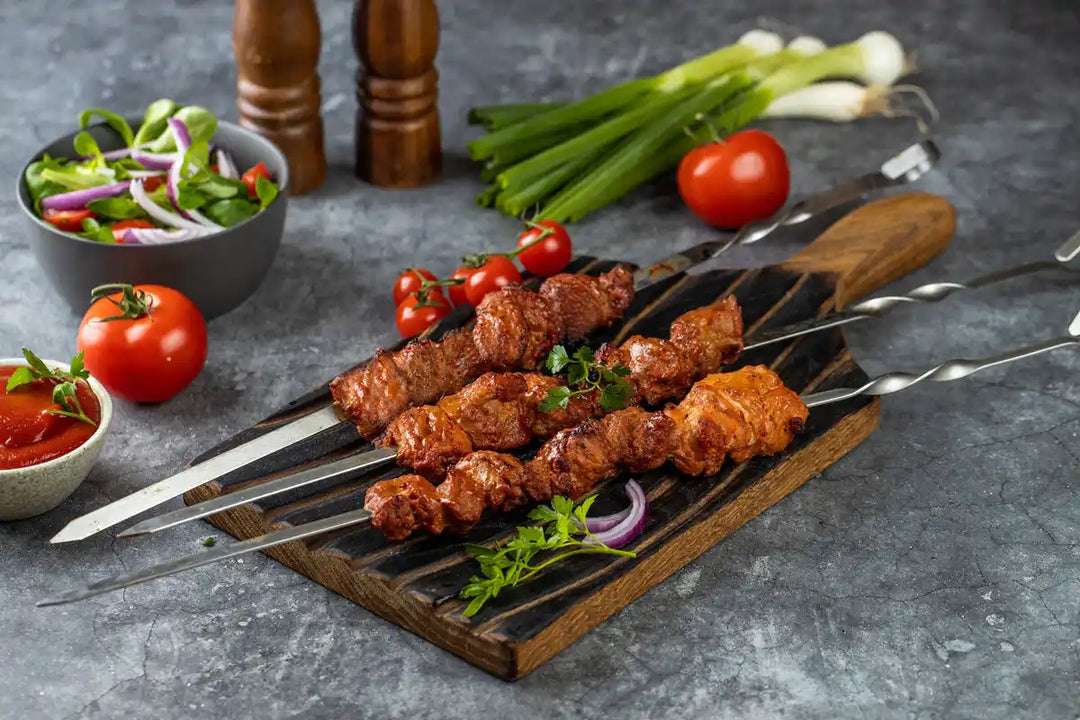 Schweine Schaschlik Tomate serviert auf Holzbrett mit Tomaten Zwiebeln und Petersilie