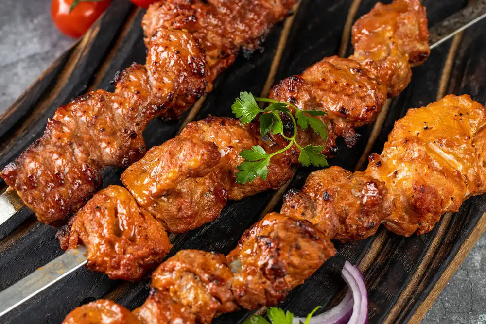 Nahaufnahme Schweine Schaschlik Tomate serviert auf Holzbrett mit Tomaten Zwiebeln und Petersilie