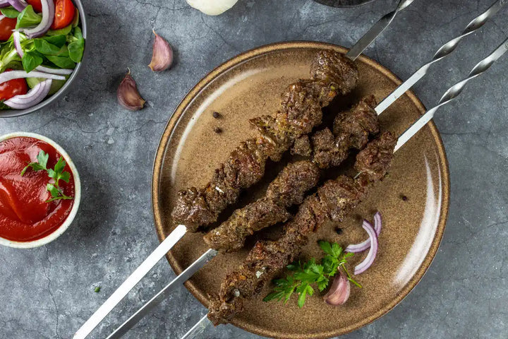 Lamm Schaschlik Knoblauch Pfeffer auf Spießen serviert auf Teller