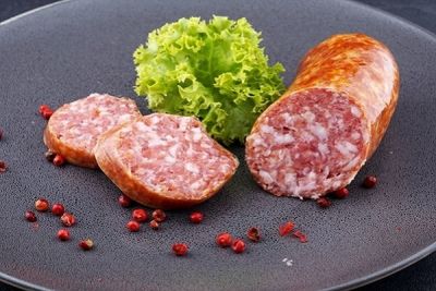 Schweinemettwurst geschnitten auf Teller mit Petersilie