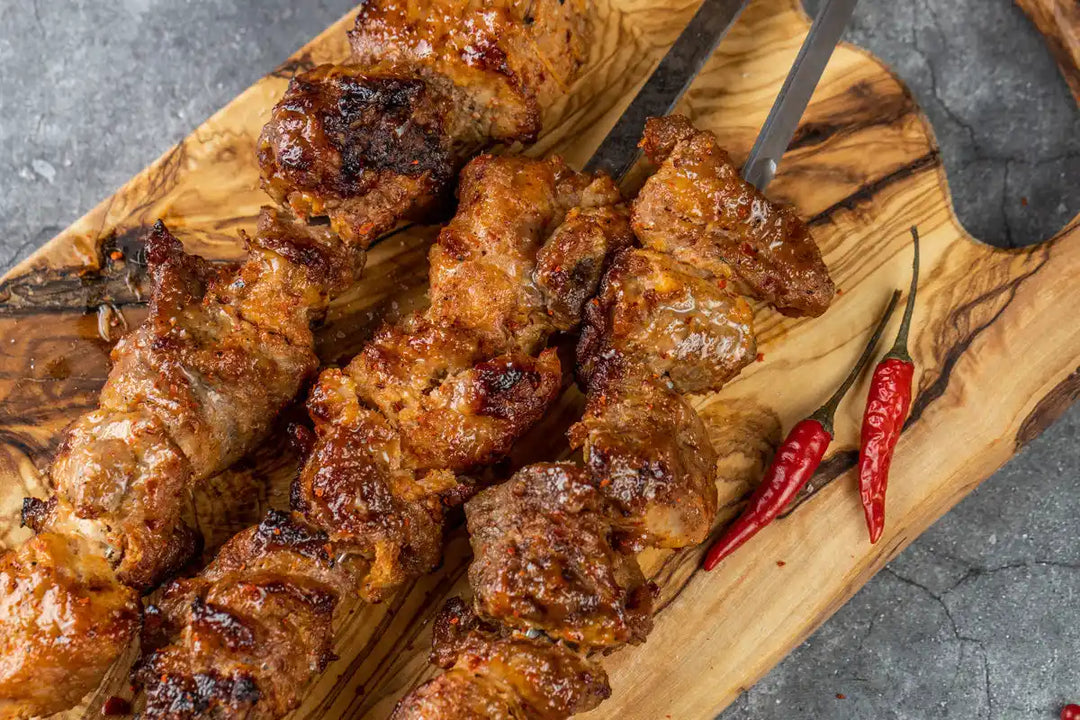 Nahaufnahme Schweine Schaschlik Chili auf Spießen serviert auf Holzbrett mit Peperoni