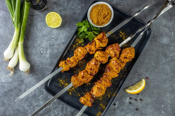 Geflügel Schaschlik Thai-Curry auf Spießen mit Curry Pulver, Lauch und Zitrone serviert